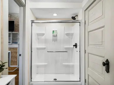 a shower with a glass door in a bathroom at Carriage Manor - Sun Soaked 1BR - Close to CCF in Cleveland