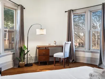 a bedroom with a desk and a chair and windows at Carriage Manor - Sun Soaked 1BR - Close to CCF in Cleveland