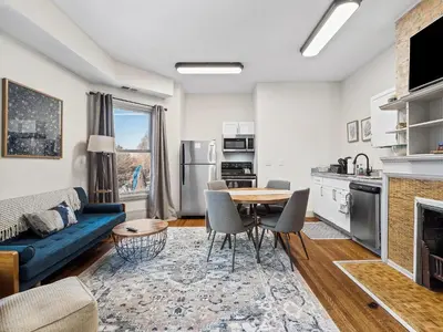 a living room with a blue couch and a table at Carriage Manor - Sun Soaked 1BR - Close to CCF in Cleveland