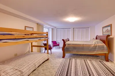a bedroom with two bunk beds and a chair at Peaceful Carrollton Retreat with Deck and Fire Pit! in Carrollton