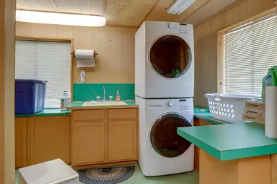 a utility room with two washing machines and a sink at Peaceful Carrollton Retreat with Deck and Fire Pit! in Carrollton