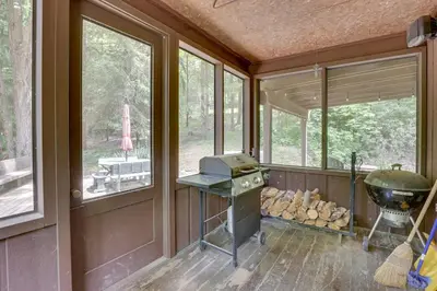 a screened in porch with a grill and windows at Peaceful Carrollton Retreat with Deck and Fire Pit! in Carrollton