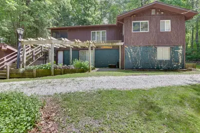 a house with a blue garage in the yard at Peaceful Carrollton Retreat with Deck and Fire Pit! in Carrollton