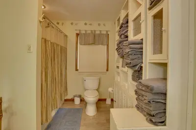 a bathroom with a toilet and a pile of towels at Peaceful Carrollton Retreat with Deck and Fire Pit! in Carrollton