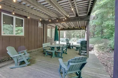 a wooden deck with chairs and a table and chairs at Peaceful Carrollton Retreat with Deck and Fire Pit! in Carrollton