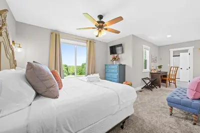 a bedroom with a bed and a ceiling fan at Home for 21 Near Ark - Ensuite Bathrooms - with Pool! in Williamstown