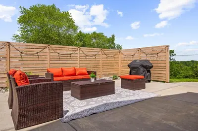 a patio with chairs and tables and a fence at Home for 21 Near Ark - Ensuite Bathrooms - with Pool! in Williamstown