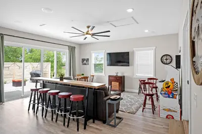 a kitchen and living room with a bar and stools at Home for 21 Near Ark - Ensuite Bathrooms - with Pool! in Williamstown