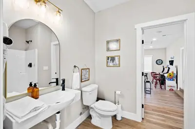 a white bathroom with a toilet and a sink at Home for 21 Near Ark - Ensuite Bathrooms - with Pool! in Williamstown