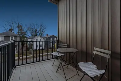 a patio with two chairs and a table on a deck at Stylish 4BR in Merion Village PD in Columbus