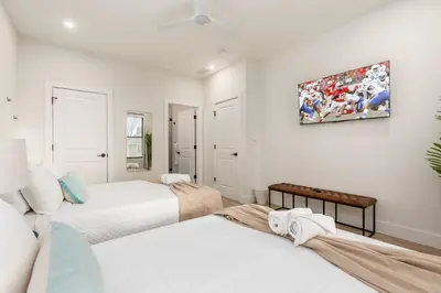 a bedroom with two beds and a painting on the wall at Stylish 4BR in Merion Village PD in Columbus