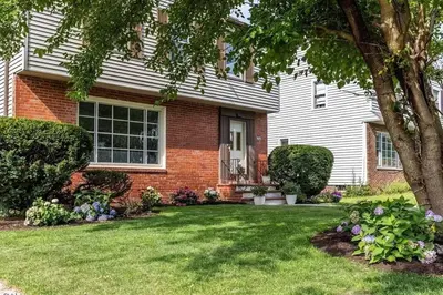 a brick house with a yard with flowers at The Italian Farmhouse in Cleveland Heights