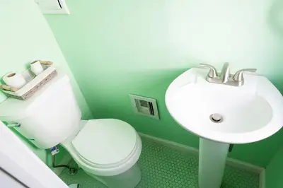 a bathroom with a white toilet and a sink at The Italian Farmhouse in Cleveland Heights