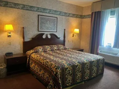 a bedroom with a bed in a hotel room at Garden Inn in New Castle
