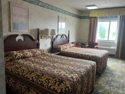 a hotel room with two beds and a window at Garden Inn in New Castle