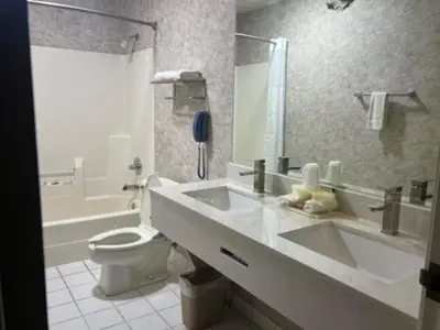 a bathroom with a sink and a toilet and a tub at Garden Inn in New Castle