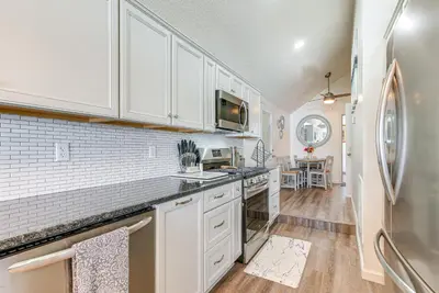 a kitchen with white cabinets and a refrigerator at Waterfront with Boat Dock Retreat on Indian Lake in Lakeview