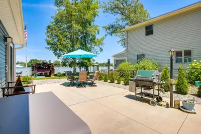 a patio with a grill and an umbrella at Waterfront with Boat Dock Retreat on Indian Lake in Lakeview