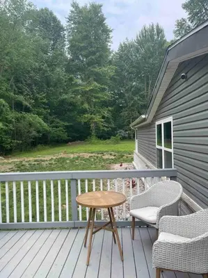 a wooden deck with a table and two chairs at Serenity away from the big city in Amelia