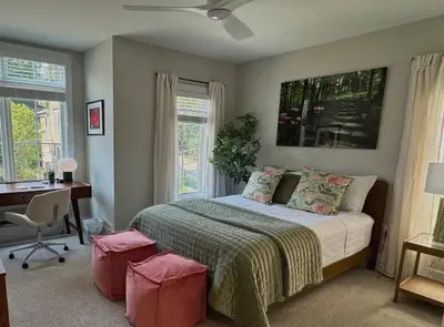 a bedroom with a bed and a desk and windows at Mt Adams Adventure in Cincinnati