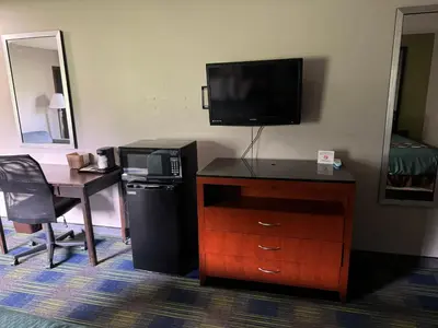 a hotel room with a desk and a tv and a desk sidx sidx sidx sidx at South Ridge Inn in North Ridgeville