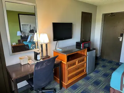a hotel room with a desk with a computer and a bed at South Ridge Inn in North Ridgeville