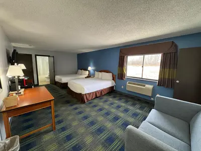 a hotel room with two beds and a couch at South Ridge Inn in North Ridgeville