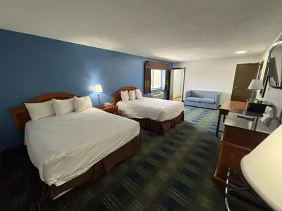 a hotel room with two beds and a couch at South Ridge Inn in North Ridgeville