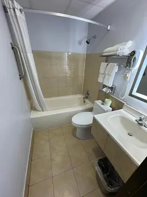 a bathroom with a tub and a toilet and a sink at South Ridge Inn in North Ridgeville