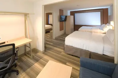 a hotel room with two beds and a desk at Holiday Inn Express & Suites Monroe by IHG in Monroe