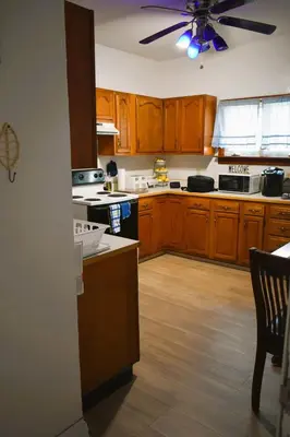 a kitchen with wooden cabinets and a ceiling fan at Lima Downtown 1 Bdrm Oasis in Lima