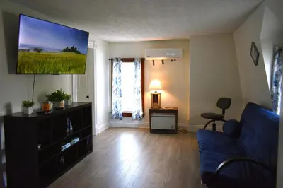 a living room with a blue couch and a flat screen tv at Lima Downtown 1 Bdrm Oasis in Lima