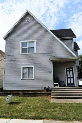 a white house with a window and a porch at Lima Downtown 1 Bdrm Oasis in Lima
