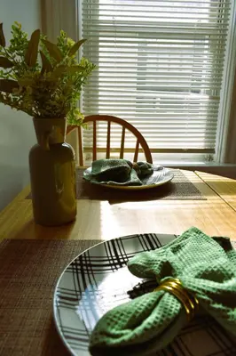 a wooden table with a plate and a vase with a plant at Spacious 2bdrm in Lima's Heart in Lima
