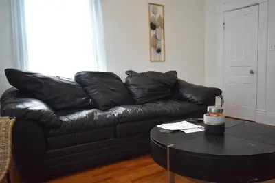a black leather couch in a living room with a table at Spacious 2bdrm in Lima's Heart in Lima