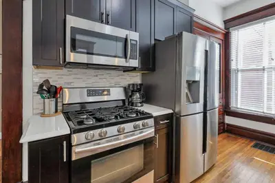 a kitchen with a stove and a stainless steel refrigerator at 4 Bed Townhome near Goodale Park in Columbus