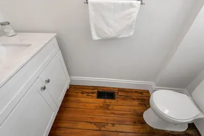 a bathroom with a toilet and a sink and wooden floor at 4 Bed Townhome near Goodale Park in Columbus