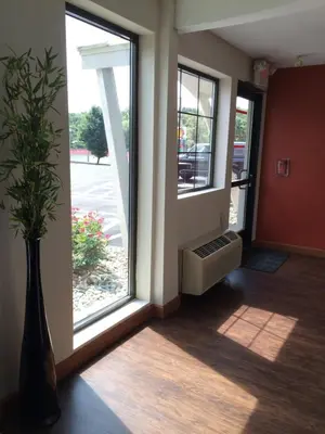a hallway with a window and a vase with a plant at The Inn in Monaca