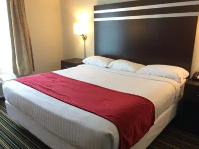 a hotel room with a large bed with a red blanket at The Inn in Monaca