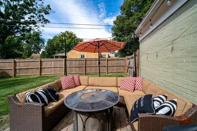 a patio with a couch and a table with an umbrella at Antique Charm 3BR Gourmet Kitchen & Large Yard in Kettering