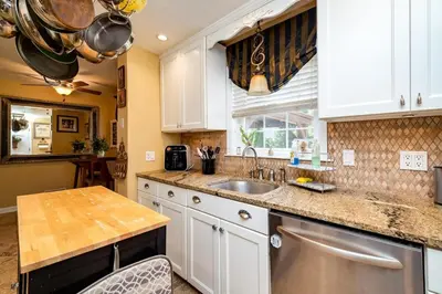 a kitchen with white cabinets and a sink at Antique Charm 3BR Gourmet Kitchen & Large Yard in Kettering