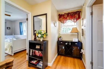 a bedroom with a mirror and a table with flowers on it at Antique Charm 3BR Gourmet Kitchen & Large Yard in Kettering