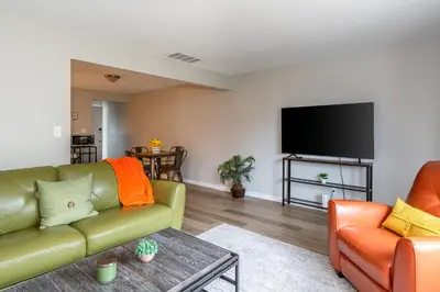 a living room with a couch and a flat screen tv at Modern 2BR Gem Steps to The Greene UD & WPAFB in Kettering