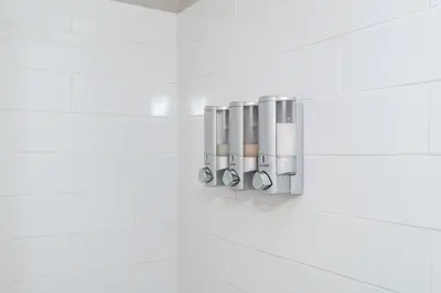 a row of silver pipes on a white tiled wall at Modern 2BR Gem Steps to The Greene UD & WPAFB in Kettering