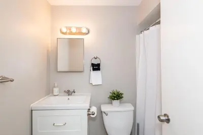 a white bathroom with a toilet and a sink at Modern 2BR Gem Steps to The Greene UD & WPAFB in Kettering