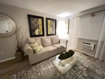 a living room with a white couch and a table at Heart Day Deal Holiday Retreat Prime Location in Kettering
