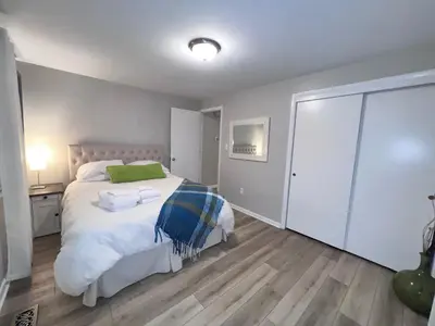 a bedroom with a large white bed with a green pillow at Heart Day Deal Holiday Retreat Prime Location in Kettering