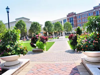 a park with flowers in front of a building at Modern Gem Steps from The Greene UD & WPAFB in Kettering