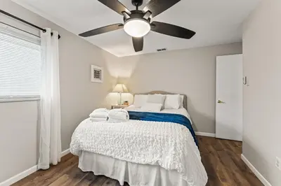 a bedroom with a bed with a ceiling fan at Close to The Greene, Escape Kalm Retreat in Kettering