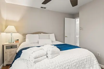 a white bedroom with a bed with towels on it at Close to The Greene, Escape Kalm Retreat in Kettering